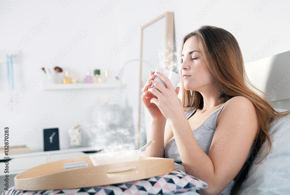 Morning at home, woman in bed drinking coffee Morning at home, woman in bed drinking coffee