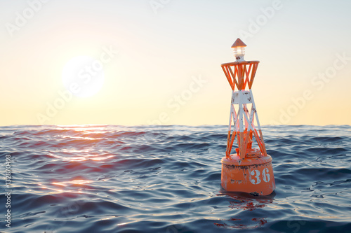 Buoy in the open sea on the sunset background. photo