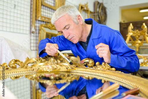 Man restoring gilt mirror