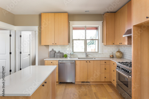 Fototapeta Naklejka Na Ścianę i Meble -  Kitchen in New Home with Hardwood Floors,New Cabinets, Oven and Range, and Dishwasher