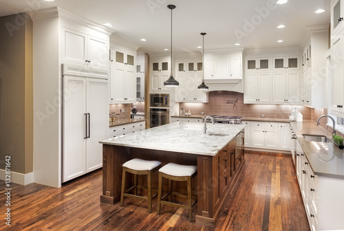 Kitchen Interior with Island, Hardwood Floors, and Pendant Lights in New Luxury Home