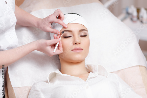 Billede på lærred Permanent make-up wizard makes eyebrow correction procedure