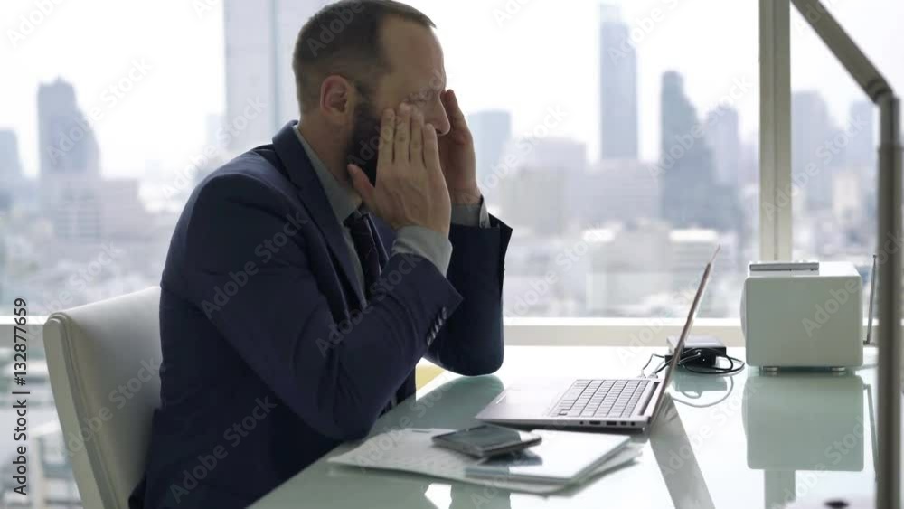 Young businessman having head pain while working on laptop in office
Young businessman having head pain while working on laptop in office