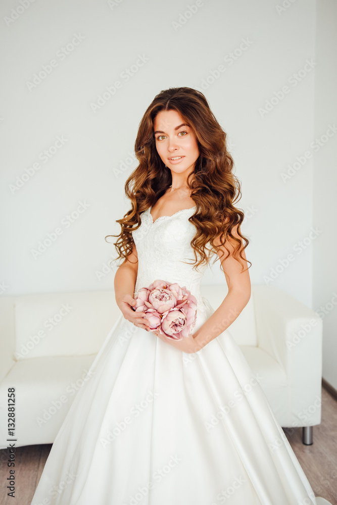 Bride.Young fashion model with perfect skin and make up, white background, curly hair, flowers Bride.Young fashion model with perfect skin and make up, white background, curly hair, flowers