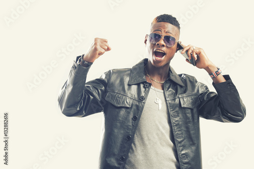 Portrait of surprised young african guy looking at cell phone
