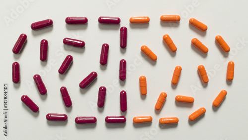 orange and red capsule laid in the form of large capsules on a white background