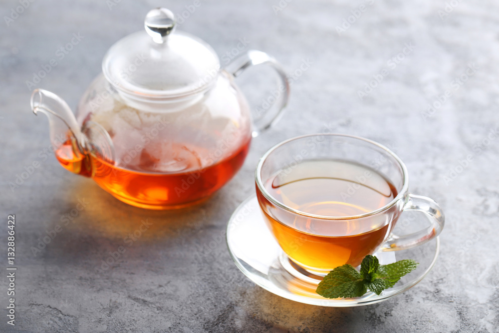 Cup of tea with mint leaf on grey wooden table Cup of tea with mint leaf on grey wooden table
