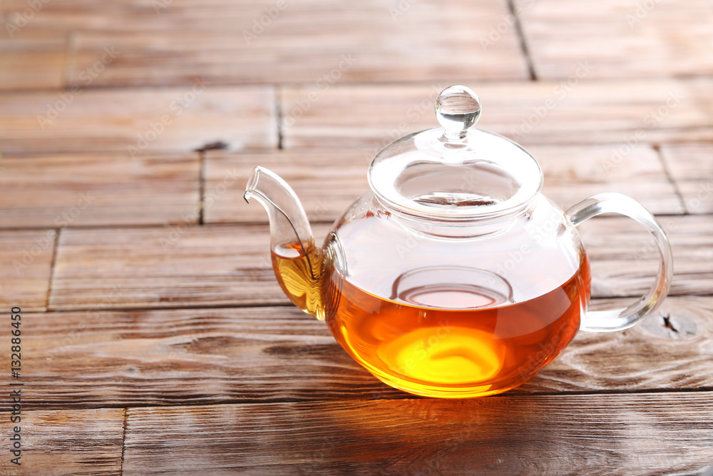 Teapot with tea on brown wooden table