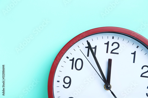 Red round clock on a mint background