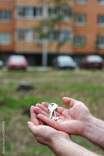 man holds keys to apartment on a background © timonko