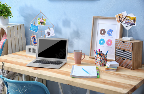 Comfortable workplace with laptop on table in modern room