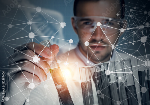 Portrait of concentrated male scientist working with reagents in laboratory