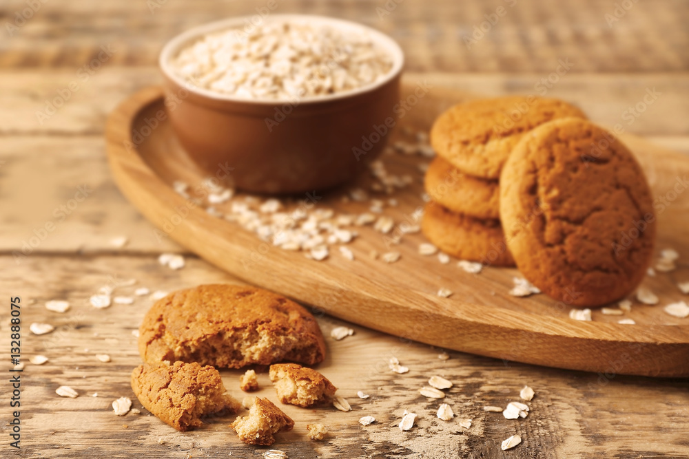 Oatmeal cookies and bowl with groats on wooden table Oatmeal cookies and bowl with groats on wooden table