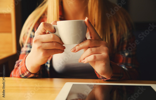 Young woman drinking coffee in cafe, close up view