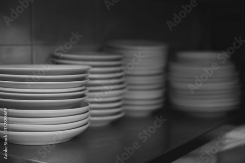 Stacked white plates on kitchen shelf
