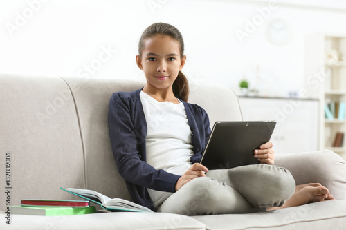 Cute girl sitting on sofa w...