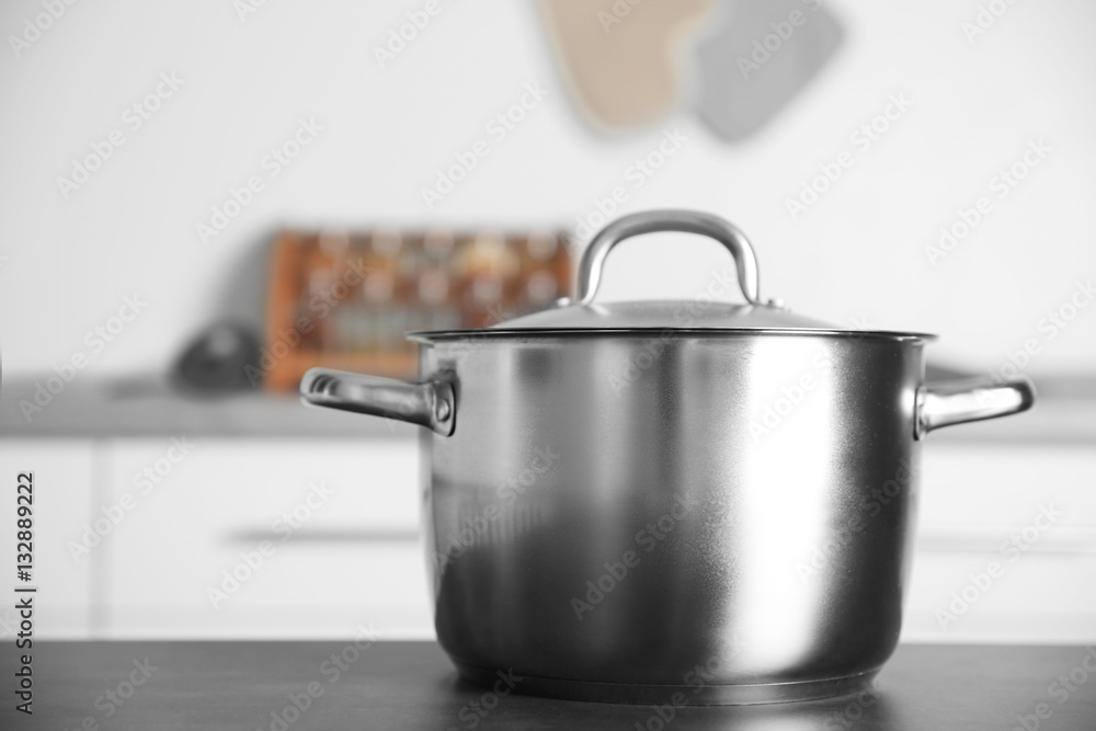 Stainless saucepan on grey kitchen table, closeup Stainless saucepan on grey kitchen table, closeup