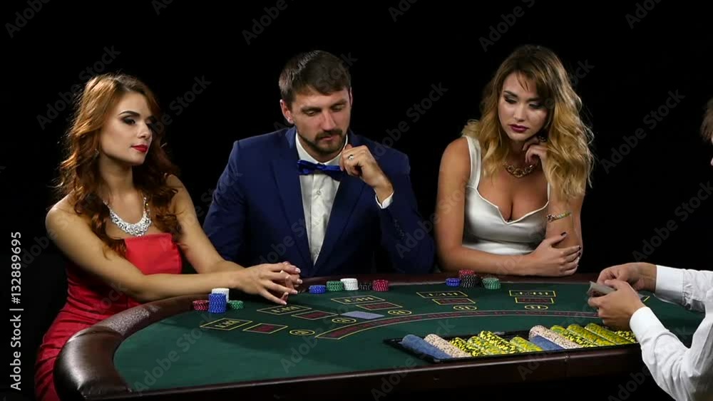 Croupier deals the card three players sitting at the table Croupier deals the card three players sitting at the table