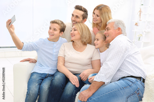 Happy family taking selfie in living room