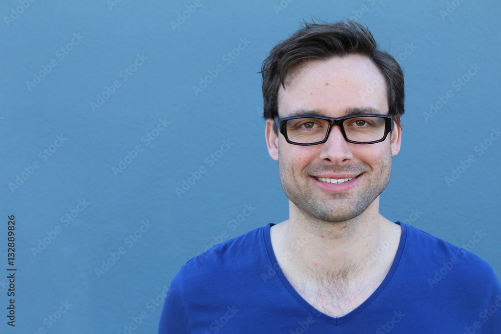 Natural good looking young man smiling with space for copy over blue background Natural good looking young man smiling with space for copy over blue background