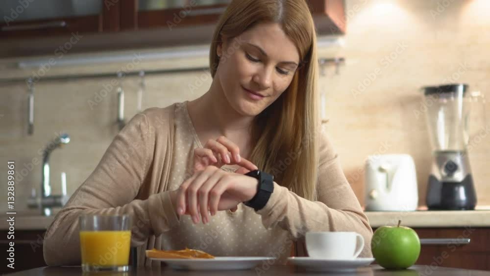 Beautiful youn woman making various gestures with a finger on a touch screen of a smart watch. Beautiful youn woman making various gestures with a finger on a touch screen of a smart watch.