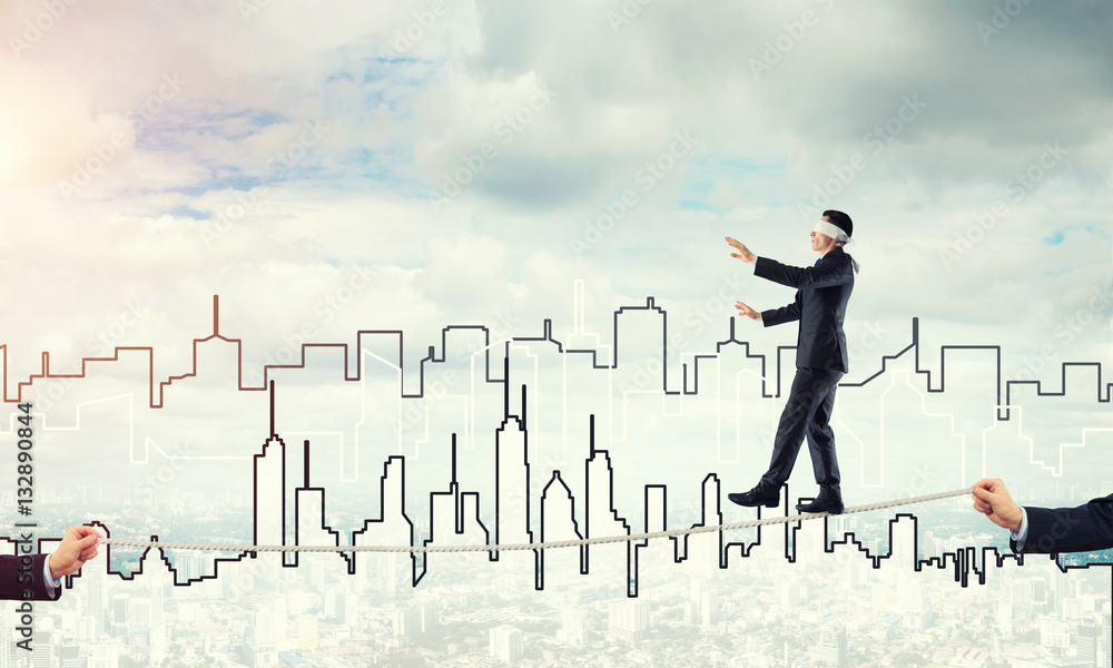 Business concept of risk support and assistance with man balancing on rope Business concept of risk support and assistance with man balancing on rope