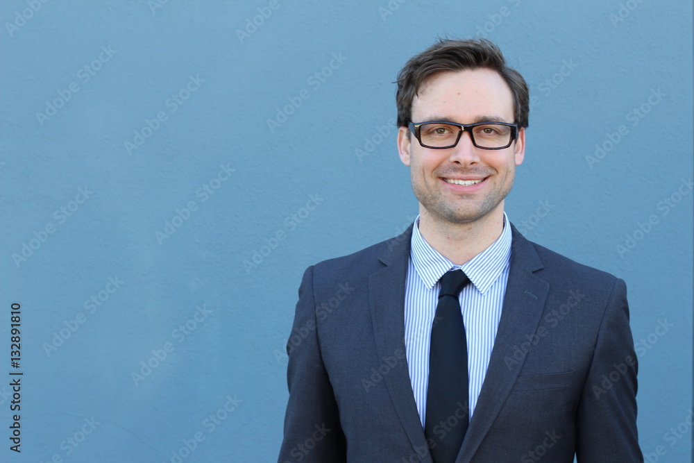 Natural good looking young businessman smiling over blue background Natural good looking young businessman smiling over blue background
