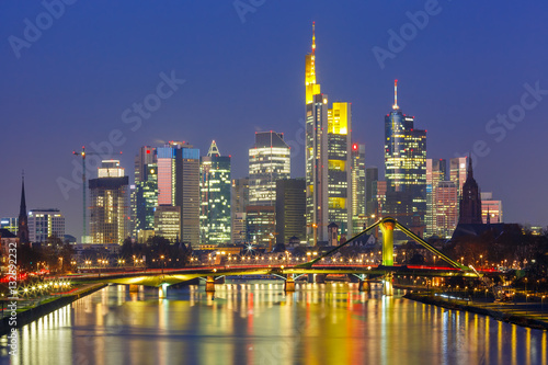 Picturesque view of business district with skyscrapers and mirror reflections in the river during morning blue hour  Frankfurt am Main  Germany