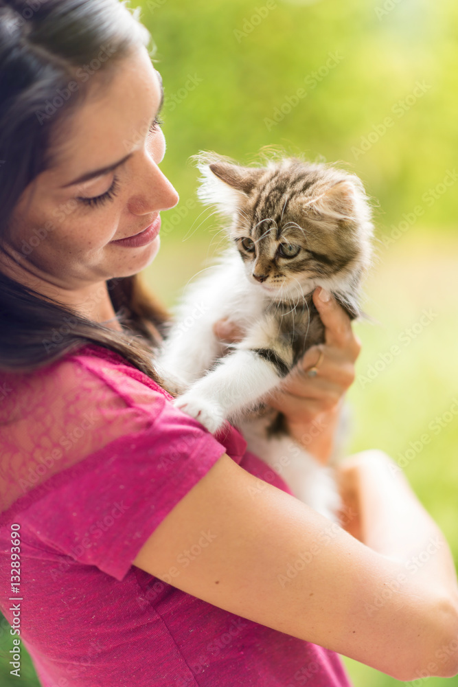 Portrait of a pretty brunette holding a little cat in her arms Portrait of a pretty brunette holding a little cat in her arms