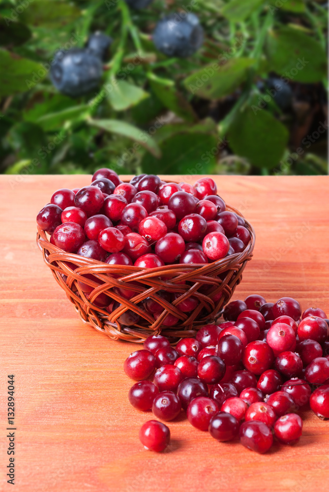 Basket with cranberries on a wooden background Basket with cranberries on a wooden background