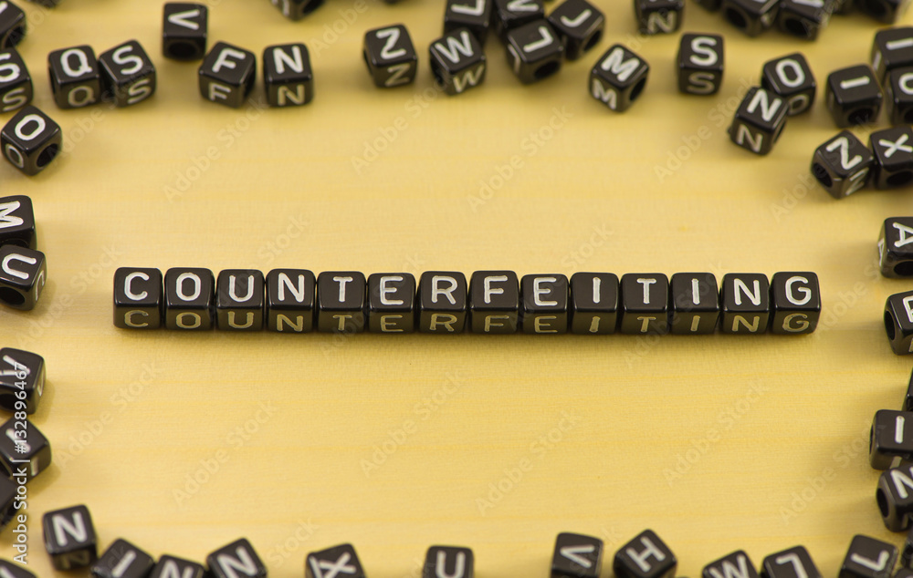 The word counterfeiting on wood background The word counterfeiting on wood background