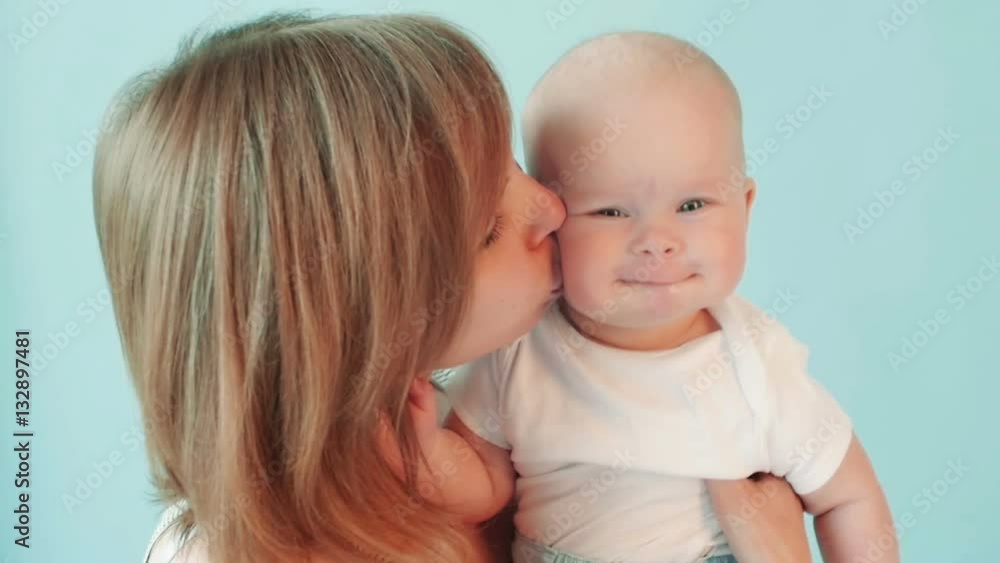 Mother kissing a baby on the cheek kindly in slow motion. Mother kissing a baby on the cheek kindly in slow motion.