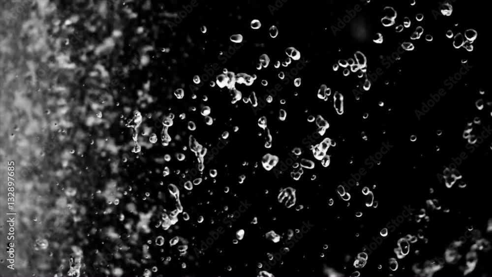 Beautiful drops of water fly slow motion on dark background Beautiful drops of water fly slow motion on dark background