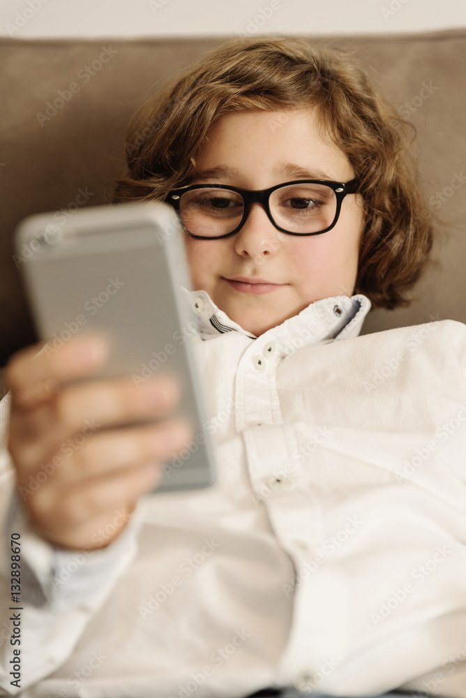 Child boy using his mobile phone.