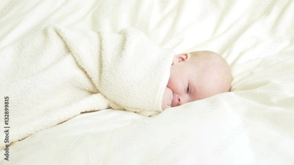 Joyful baby plays with a fluffy blanket in the bed. Joyful baby plays with a fluffy blanket in the bed.