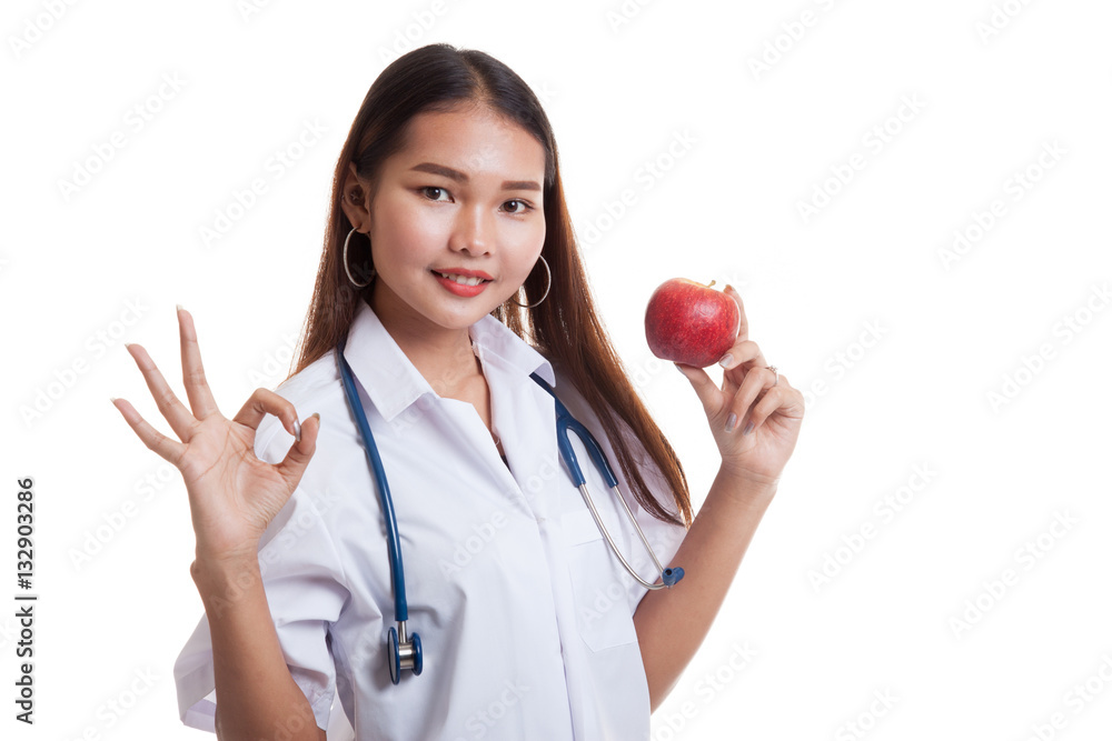 Young Asian female doctor show OK with apple. Young Asian female doctor show OK with apple.