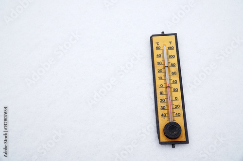 old thermometer on white snow background