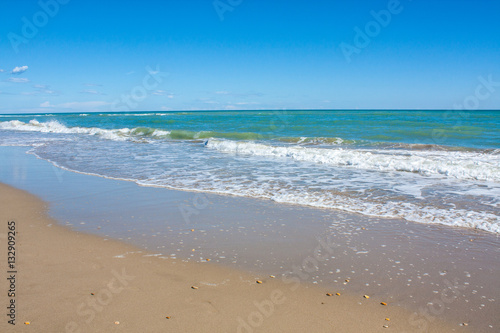 Adriatic Sea coast view. Seashore of Italy  summer sandy beach with clouds on horizon.