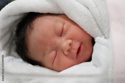 Newborn baby wrapped in white diaper