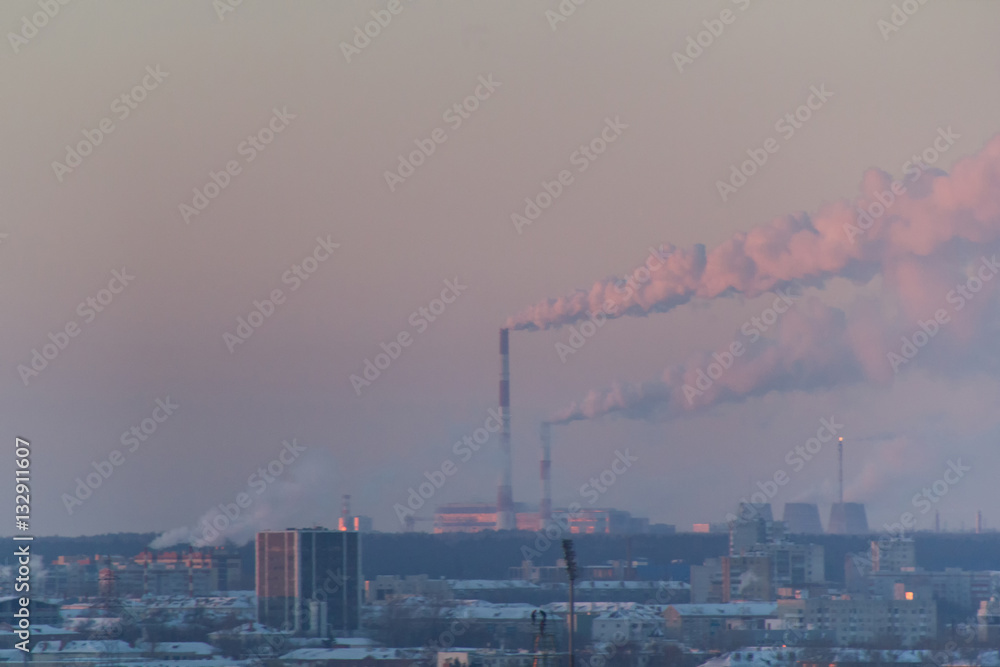 Industrial landscape with smoking pipes at winter sunset, global warming concept Industrial landscape with smoking pipes at winter sunset, global warming concept