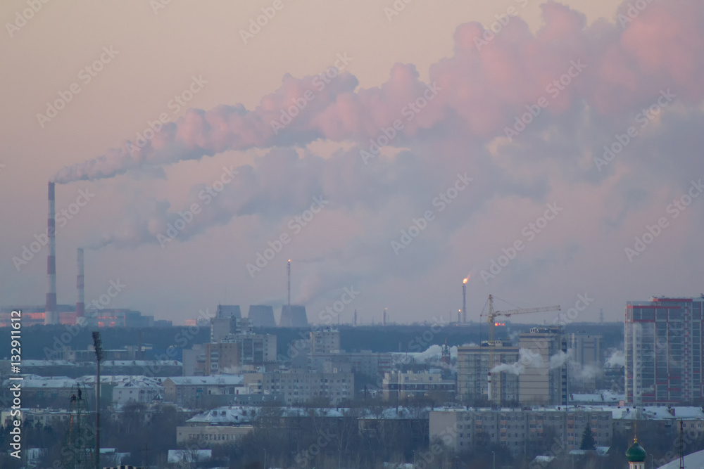 Industrial view with smoking pipes at winter sunset, chemistry concept