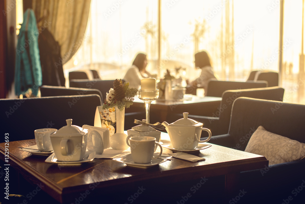 table with hot tea on a background of silhouettes girls