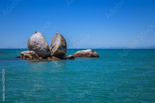 Split Apple rock landmark in landscape with blue ocean and clear sky, Abel Tasman New Zealand photo