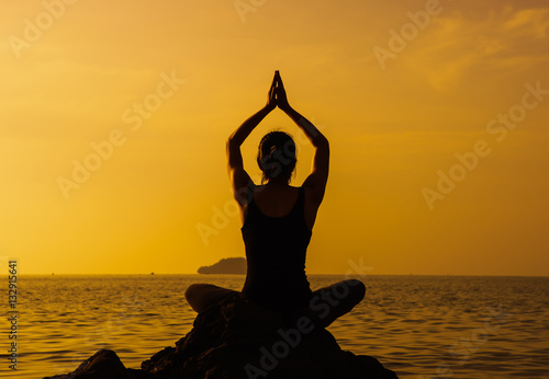 Woman meditation on sunset beach