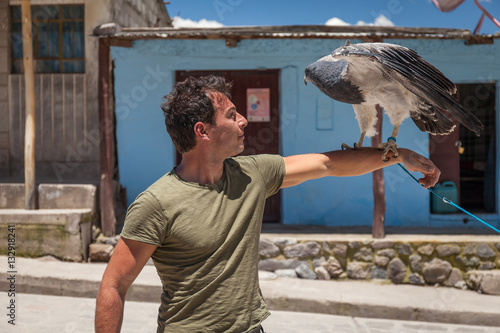 Caucasian man with trained eagle over his arm