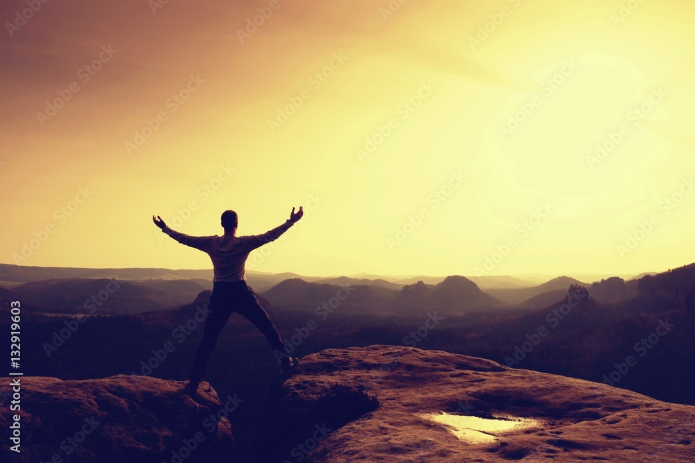 Summit achievemnt. Hiker in black celebrate triumph