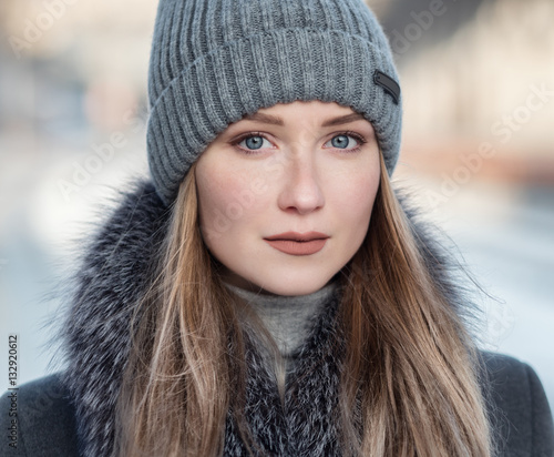 Portrait of young woman at sunny winter day.