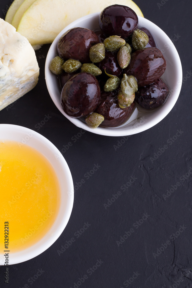olives, honey and cheese on a black background olives, honey and cheese on a black background