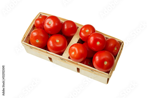 Ripe tomatoes in a wicker basket isolated on white.