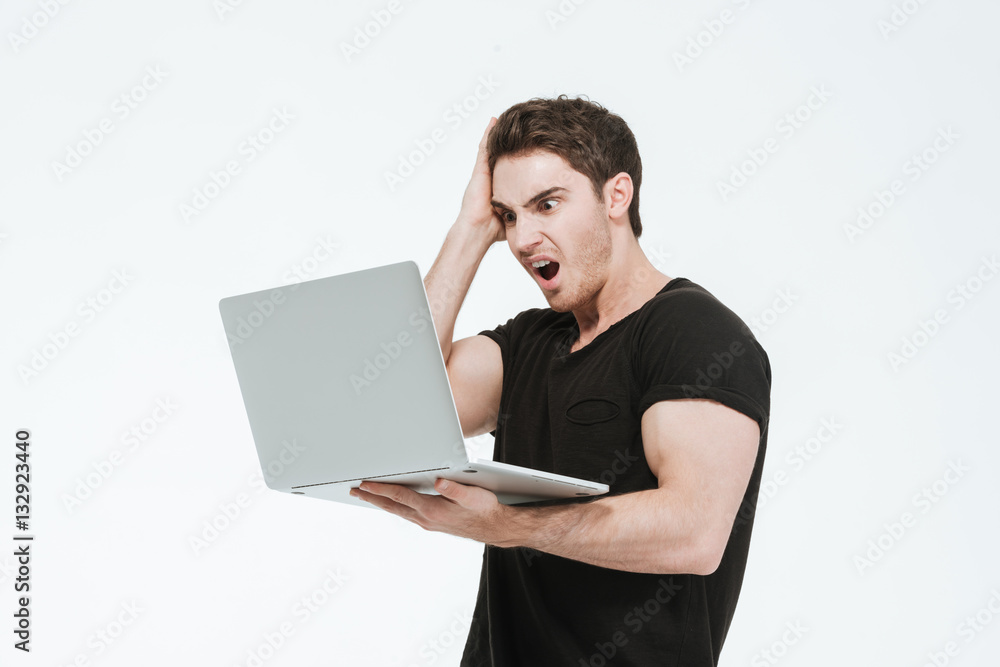 Confused young man using laptop computer. Confused young man using laptop computer.
